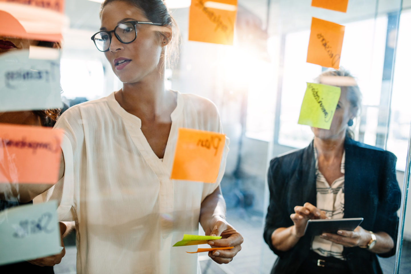 Creative professionals looking over a post it note wall and discussing